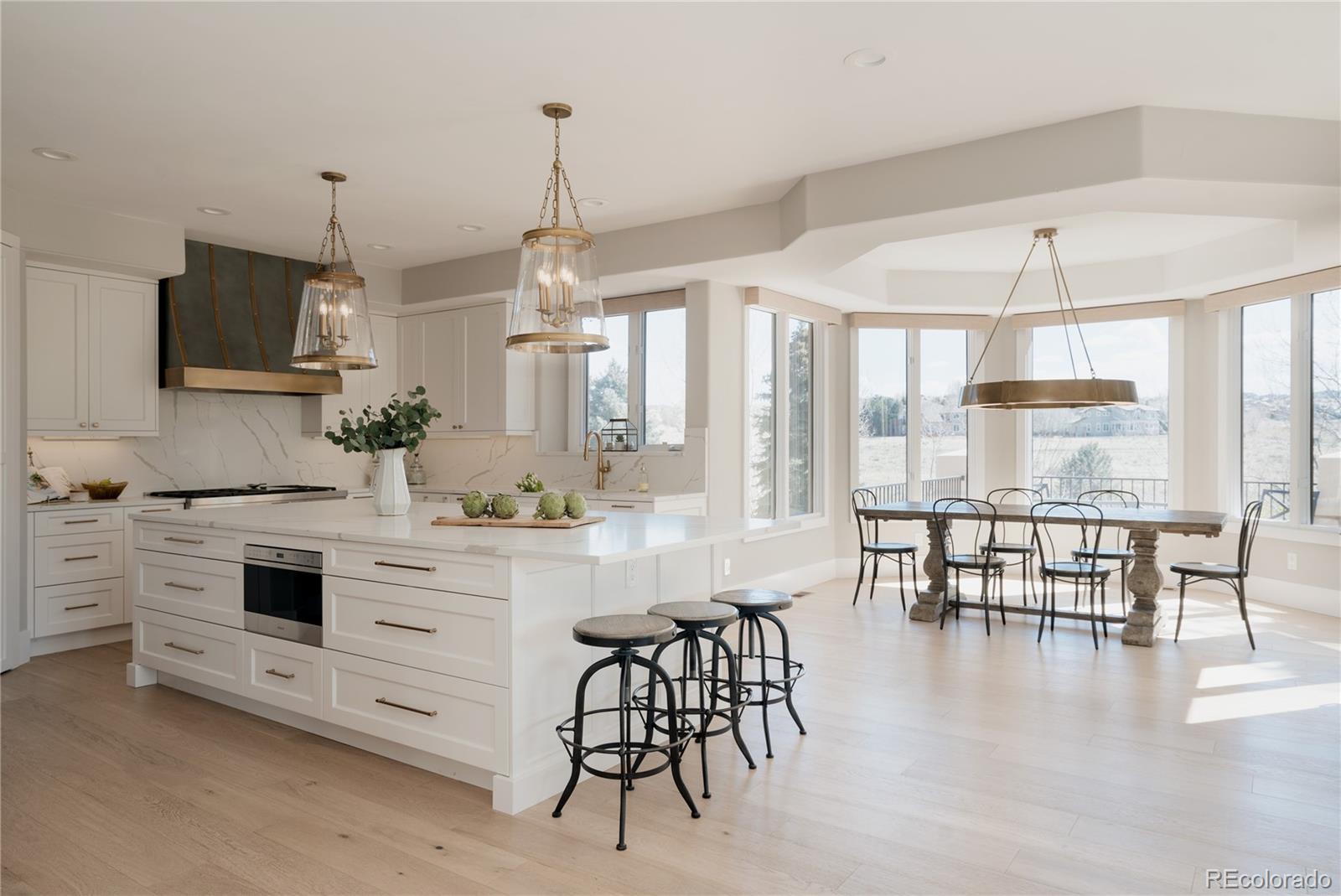 298 Fairchild Drive Highlands Ranch, CO 80126 - Photo 11 of 50 a kitchen with stainless steel appliances a stove a table and chairs in it