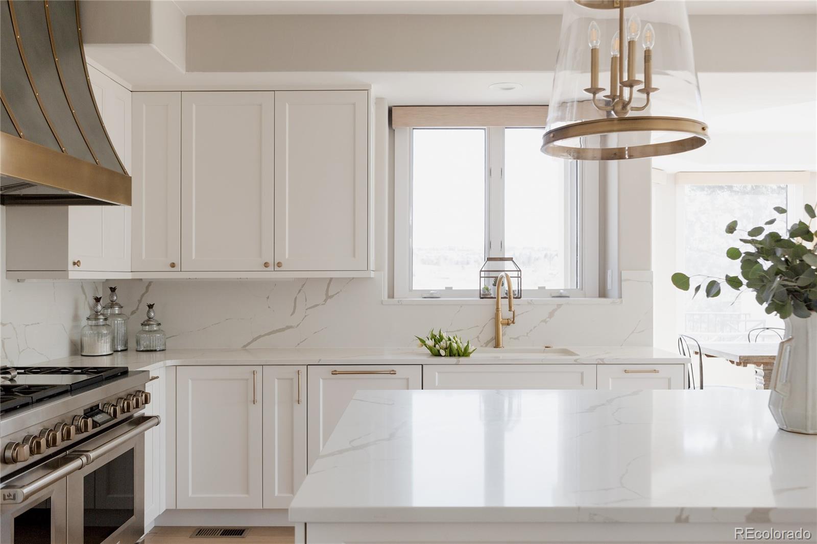 298 Fairchild Drive Highlands Ranch, CO 80126 - Photo 12 of 50 a kitchen with stainless steel appliances granite countertop a stove a sink and a white cabinets