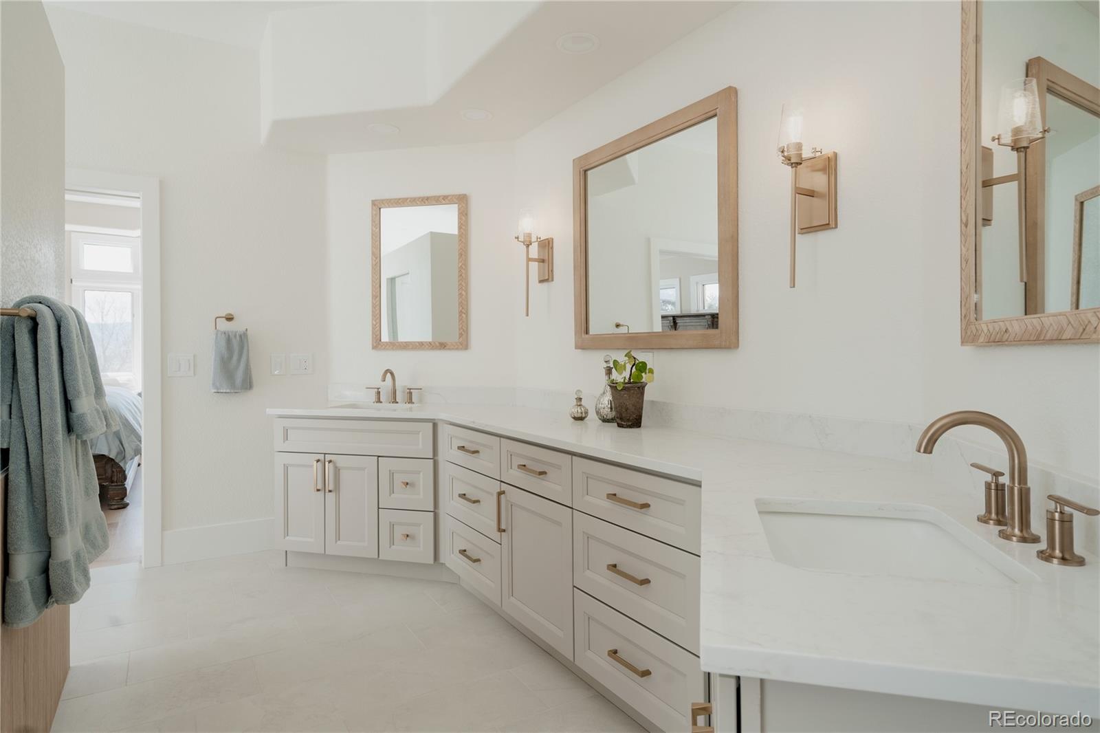 298 Fairchild Drive Highlands Ranch, CO 80126 - Photo 25 of 50 a bathroom with double vanity sink a two mirror a window and a bathtub