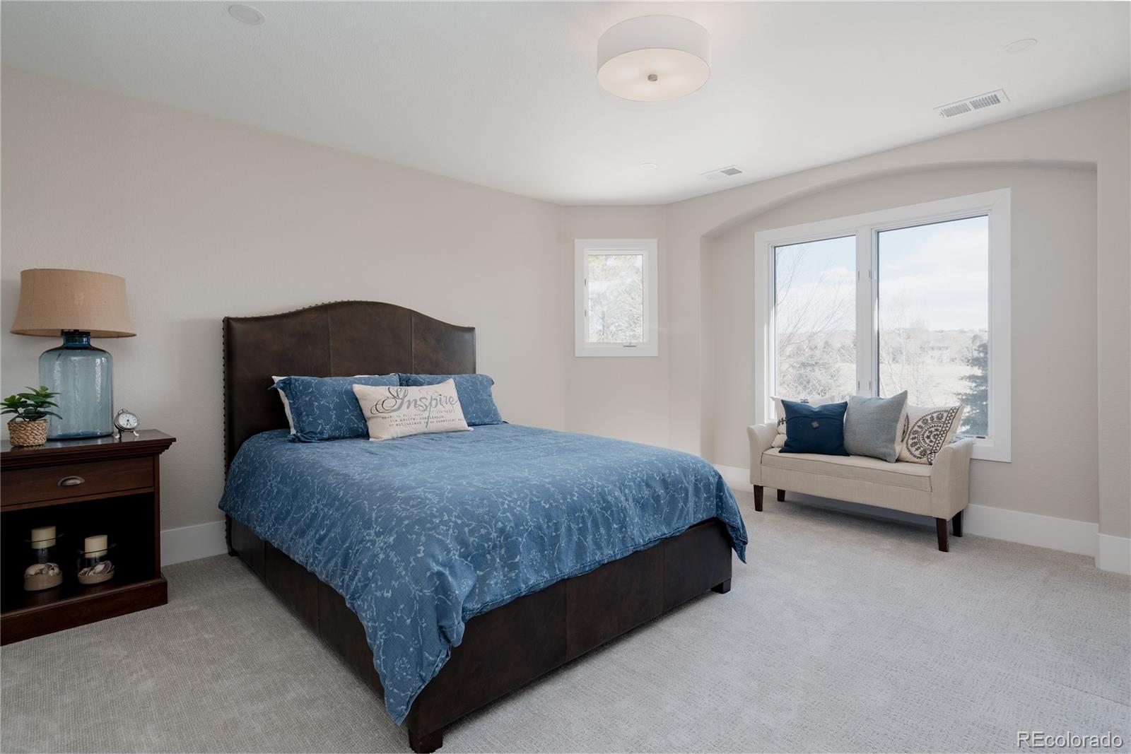 298 Fairchild Drive Highlands Ranch, CO 80126 - Photo 32 of 50 a spacious bedroom with a bed and a couch