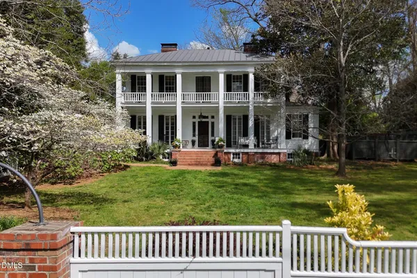 a front view of a house with a tree