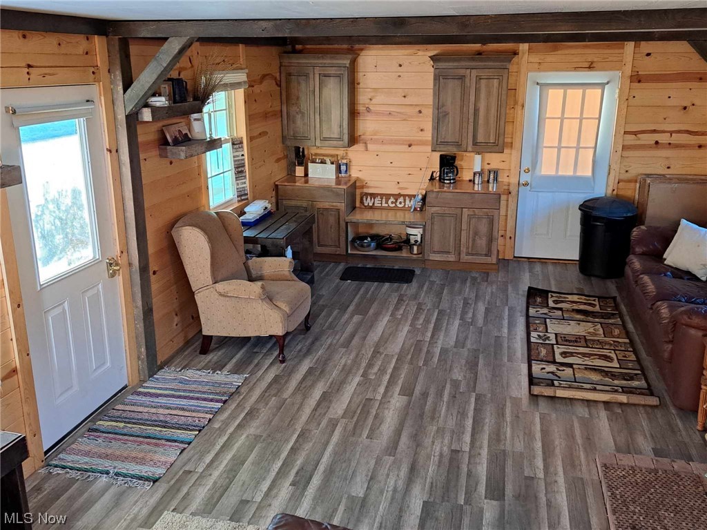 13955 T-Ridge Road Caldwell, OH 43724 - Photo 20 of 45 Living Room featuring Wood Walls, Beam Ceiling, and LVT Flooring