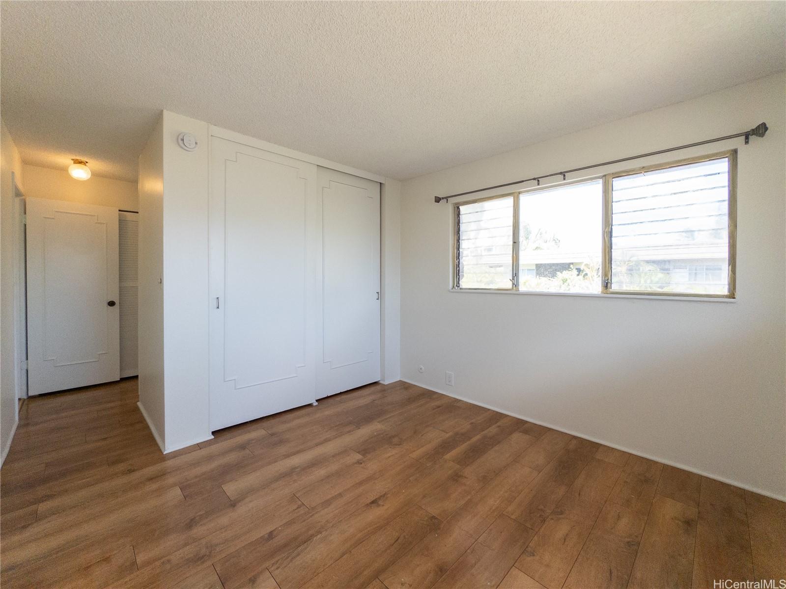 444 Lunalilo Home Road, Unit 506 Honolulu, HI 96825 - Photo 5 of 13 an empty room with wooden floor and windows