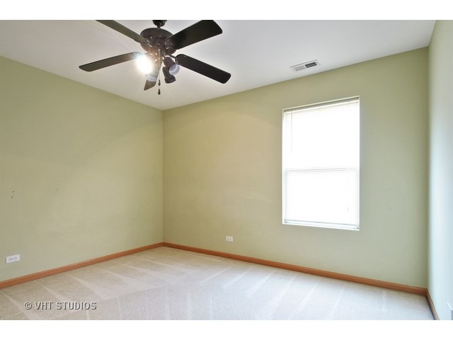 1544 Suncrest Lane Bolingbrook, IL 60490 - Photo 12 of 15 an empty room with a window and a ceiling fan