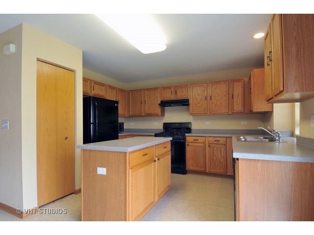 1544 Suncrest Lane Bolingbrook, IL 60490 - Photo 3 of 15 a kitchen with a stove a refrigerator and a sink