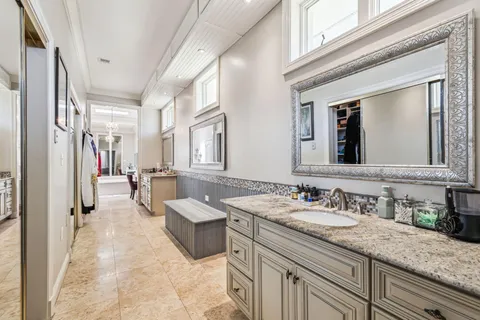 a spacious bathroom with a granite countertop sink mirror and bathtub