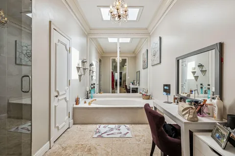 a spacious bathroom with a tub shower and a mirror