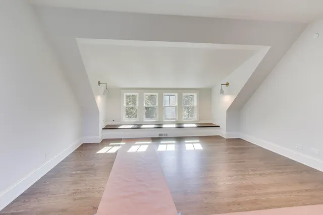 a view of a bedroom with wooden floor and windows