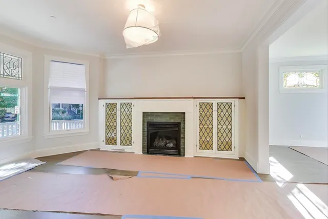 a view of an empty room with a fireplace and a window