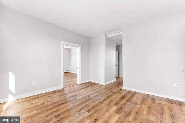 a view of empty room with wooden floor