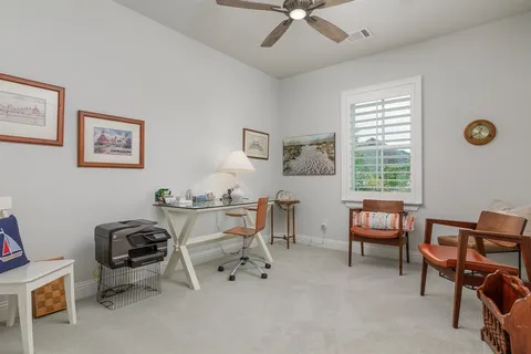 a view of a workspace with furniture and a window