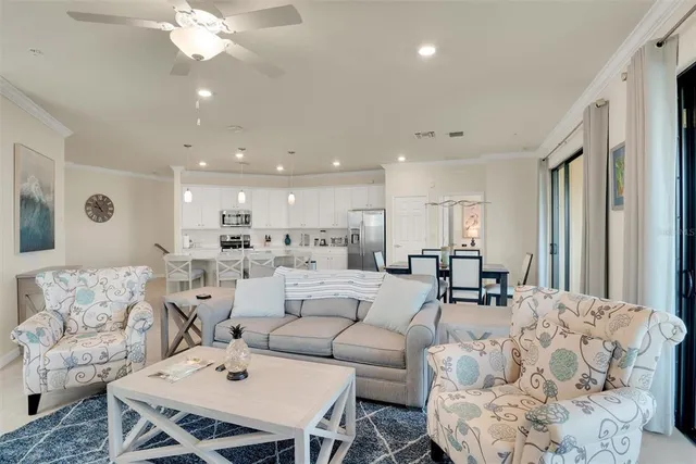 a bedroom with a large bed and a chandelier fan