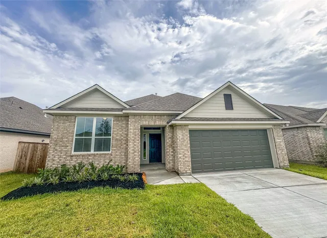 a front view of a house with a garden and yard