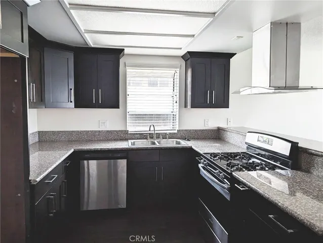 a kitchen with granite countertop a sink stove and cabinets