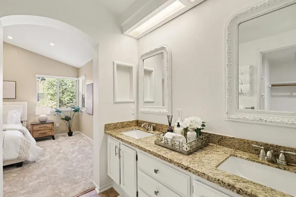 a bathroom with a granite countertop sink mirror vanity and toilet