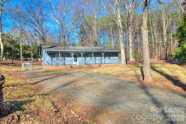 a view of house with yard and trees in the background