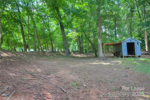 a view of a house with backyard and trees