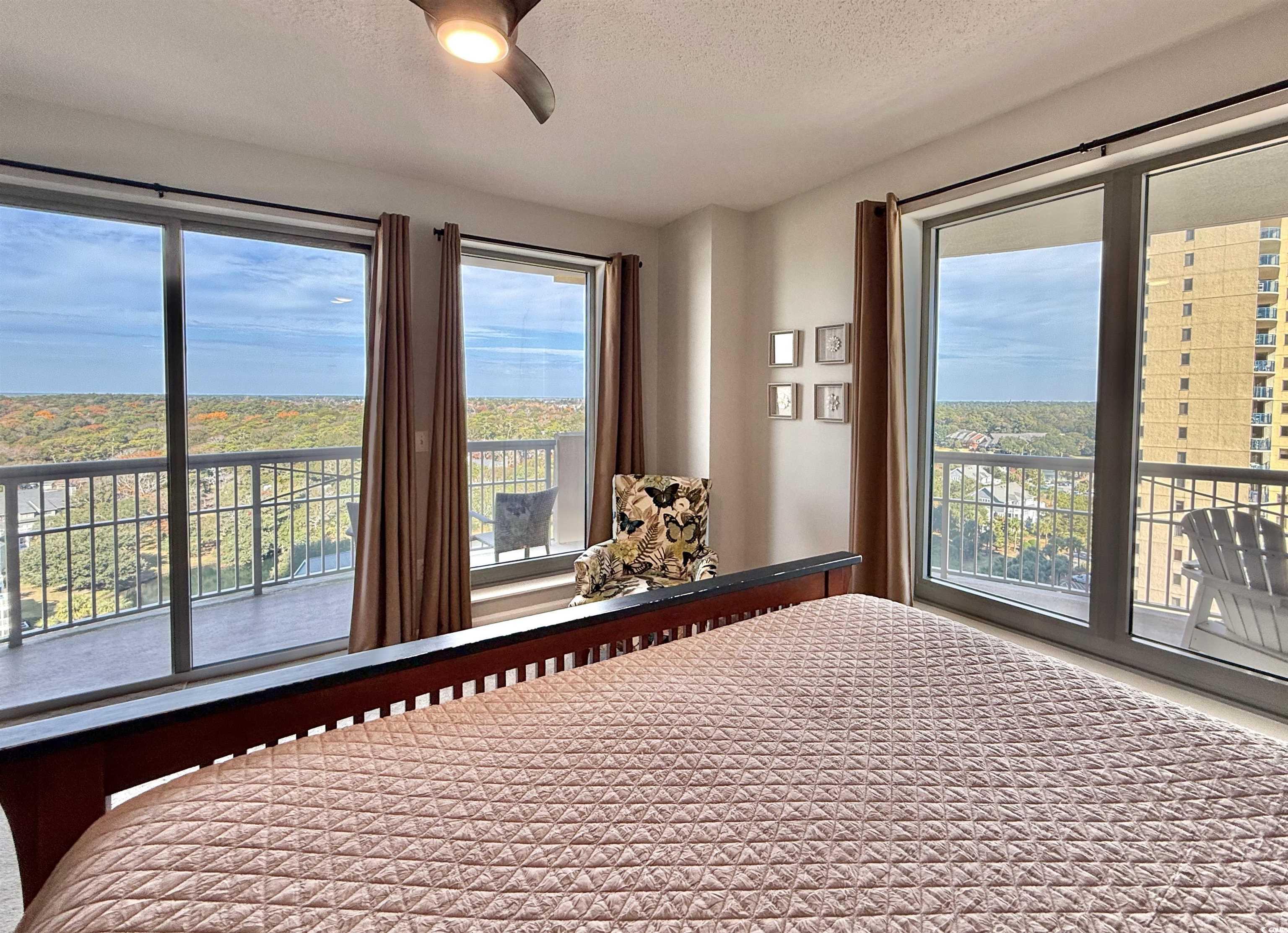 8500 Margate Circle, Unit 1108 Myrtle Beach, SC 29572 - Photo 14 of 40 Bedroom featuring access to exterior, a textured ceiling, multiple windows, and a ceiling fan