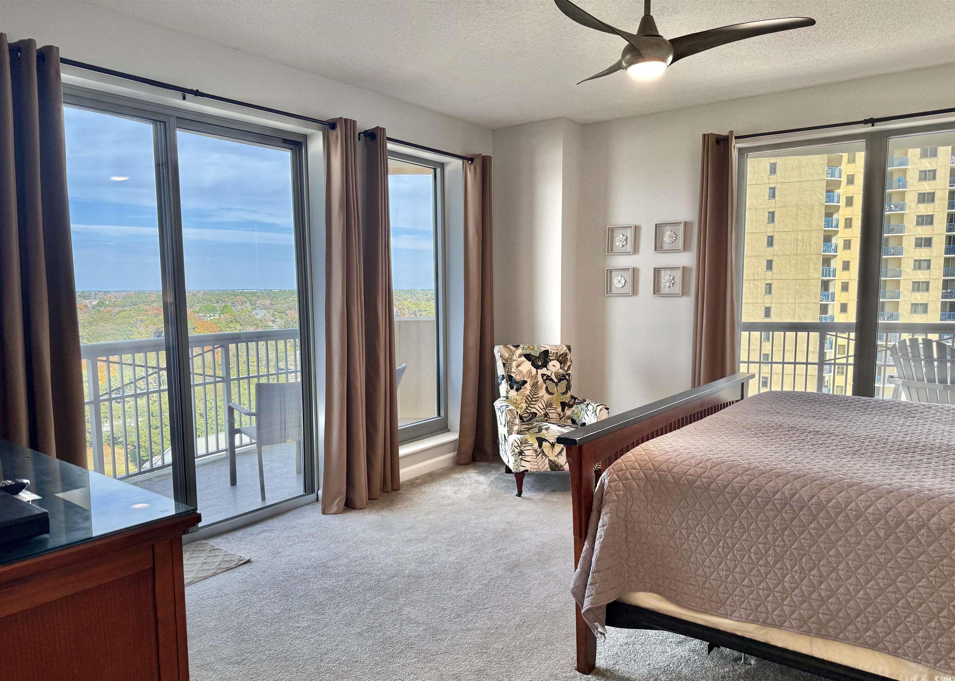 8500 Margate Circle, Unit 1108 Myrtle Beach, SC 29572 - Photo 16 of 40 Bedroom featuring access to outside, light colored carpet, a textured ceiling, multiple windows, and a ceiling fan