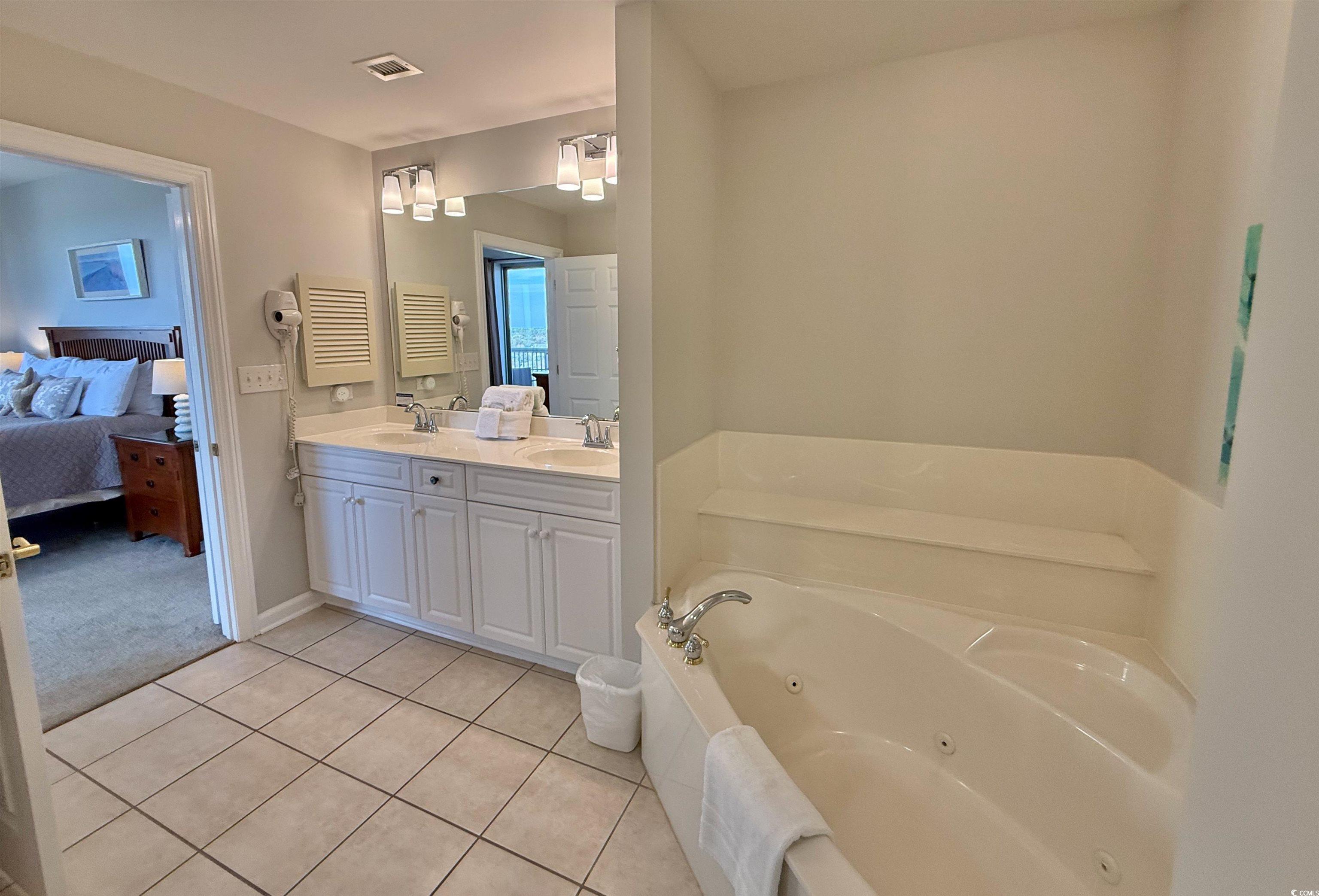 8500 Margate Circle, Unit 1108 Myrtle Beach, SC 29572 - Photo 19 of 40 Ensuite bathroom featuring double vanity, a tub with jets, and light tile patterned floors