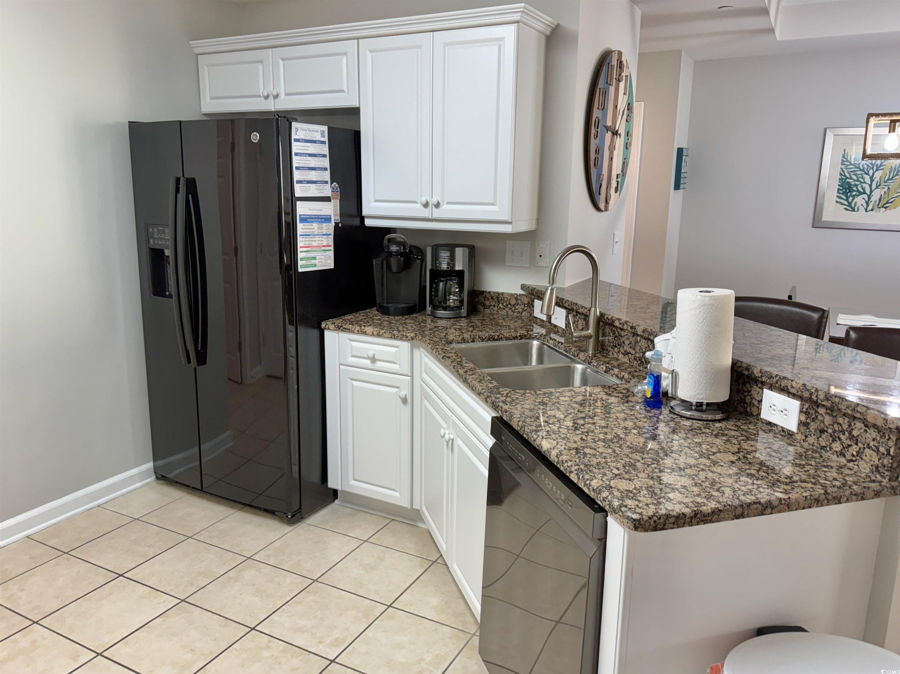 8500 Margate Circle, Unit 1108 Myrtle Beach, SC 29572 - Photo 22 of 40 Kitchen featuring white cabinets, black appliances, dark stone counters, a peninsula, and light tile patterned floors