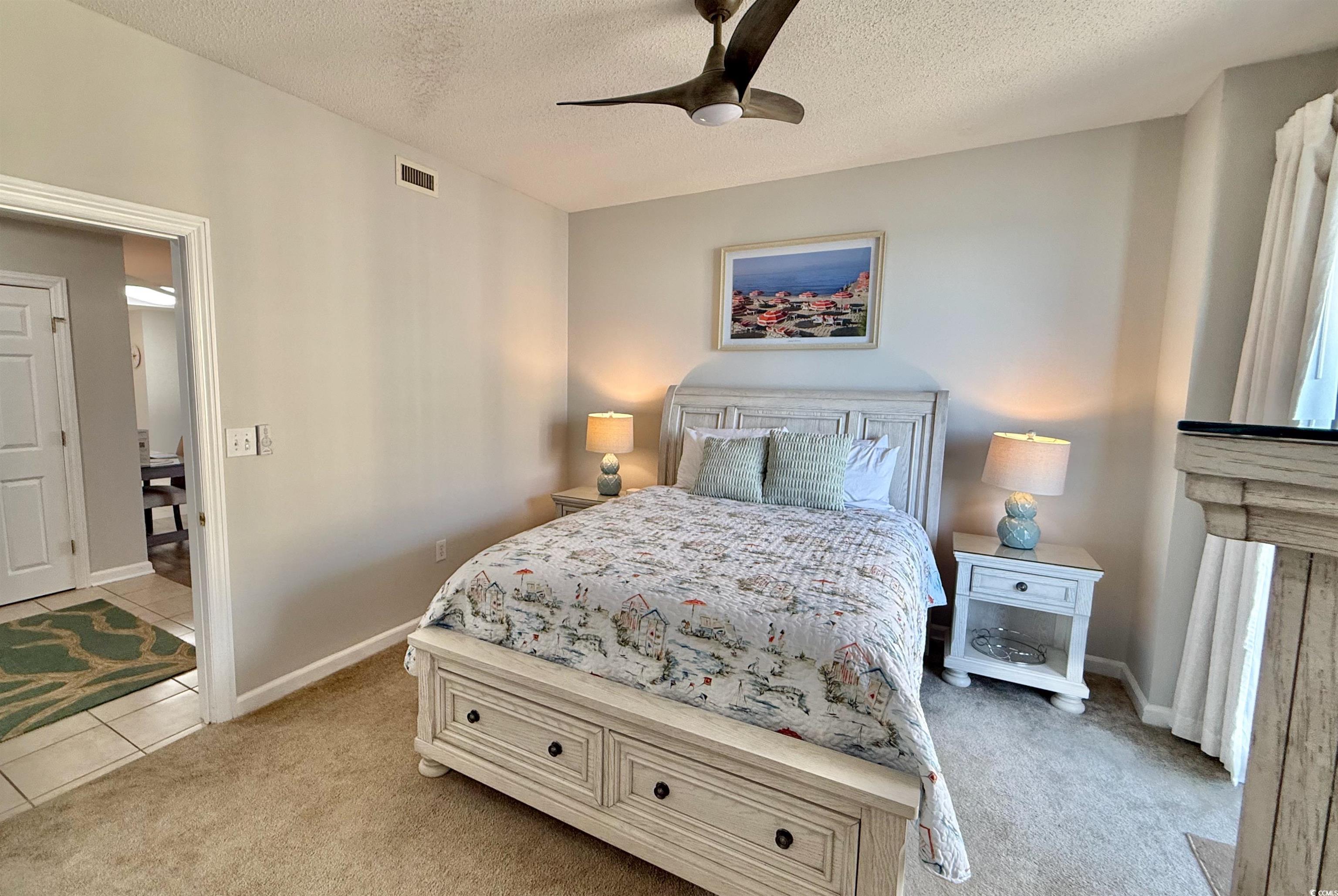 8500 Margate Circle, Unit 1108 Myrtle Beach, SC 29572 - Photo 34 of 40 Bedroom with a textured ceiling, light carpet, and ceiling fan
