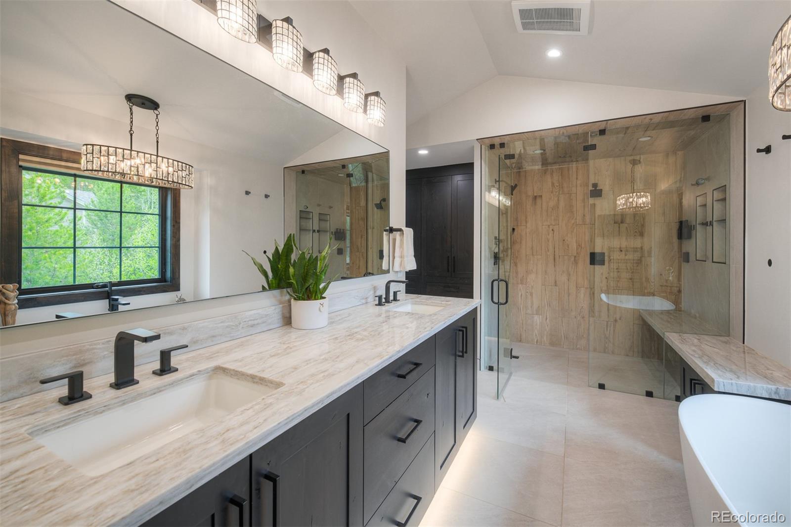 306 Golden Eagle Road Silverthorne, CO 80498 - Photo 22 of 43 a bathroom with a granite countertop sink a large mirror a bathtub and next to a window