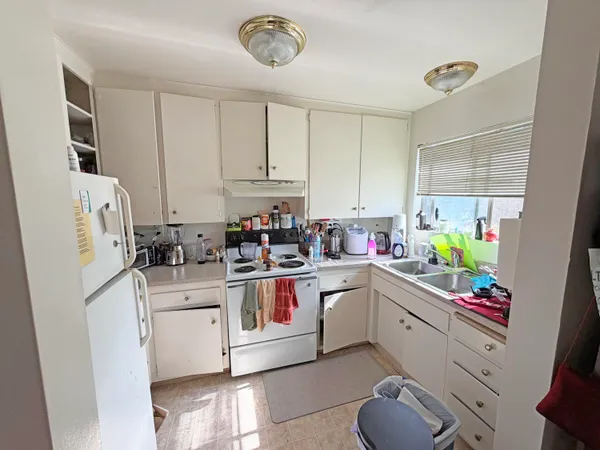 a kitchen with white cabinets and white appliances