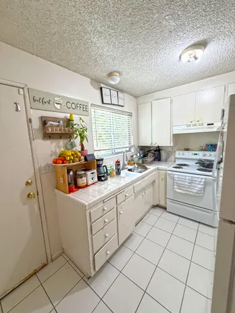a kitchen with white cabinets and white appliances