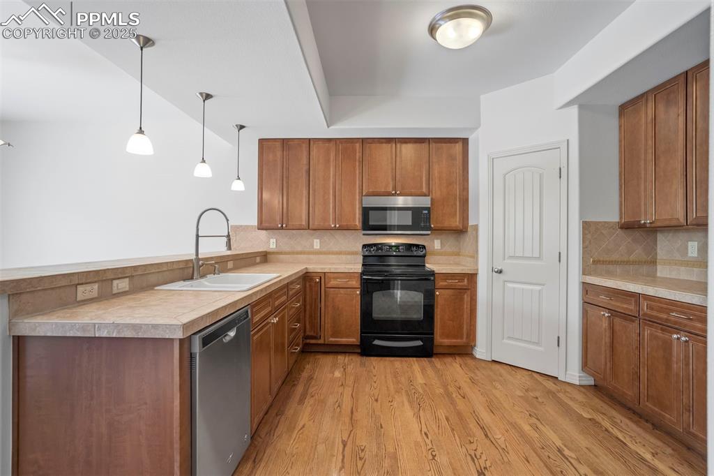 1571 Promontory Bluff View Colorado Springs, CO 80921 - Photo 11 of 49 a kitchen with stainless steel appliances granite countertop a sink stove and refrigerator
