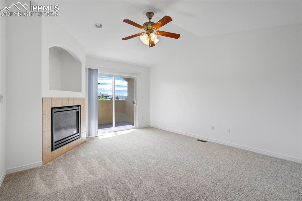 1571 Promontory Bluff View Colorado Springs, CO 80921 - Photo 17 of 49 an empty room with chandelier fan and fireplace