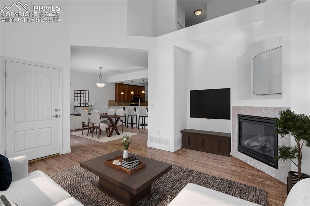 1571 Promontory Bluff View Colorado Springs, CO 80921 - Photo 3 of 49 a living room with furniture a fireplace and a flat screen tv