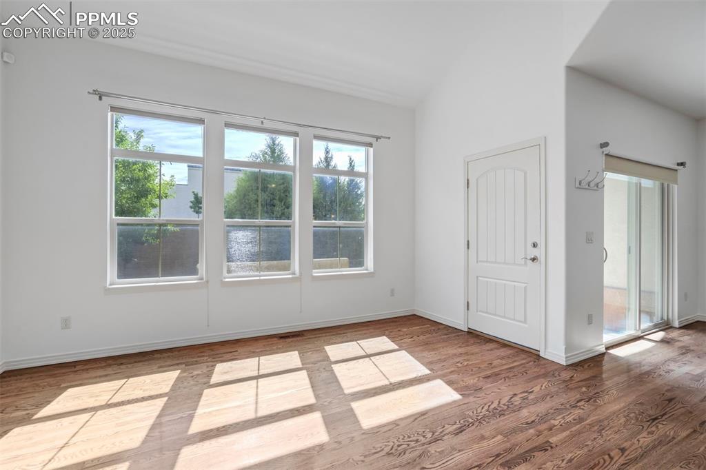1571 Promontory Bluff View Colorado Springs, CO 80921 - Photo 7 of 49 a view of an empty room with wooden floor and a window