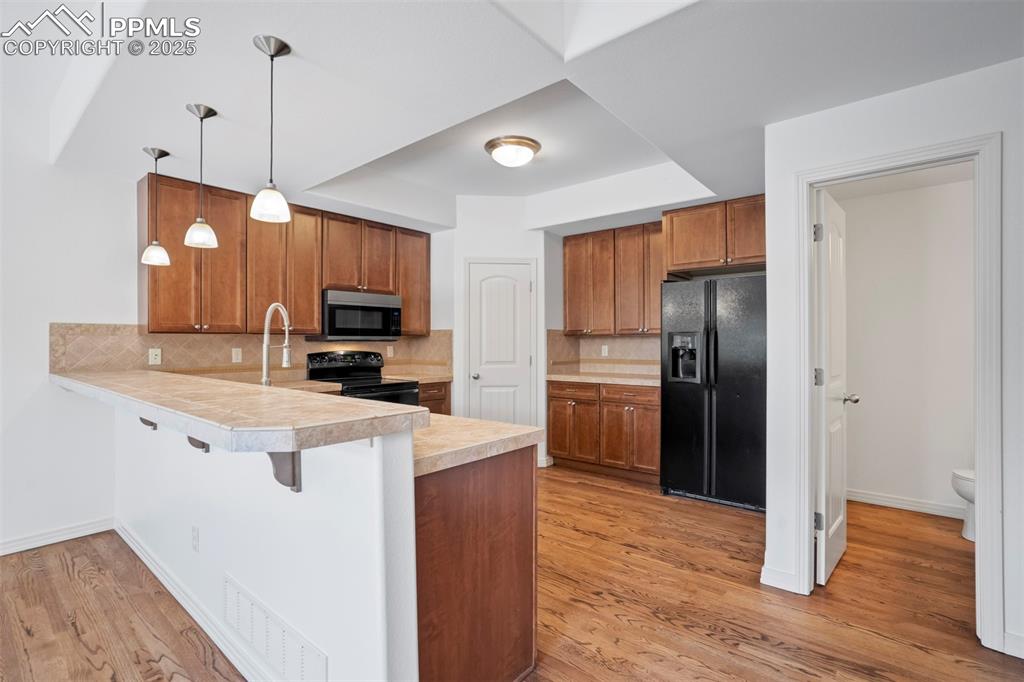 1571 Promontory Bluff View Colorado Springs, CO 80921 - Photo 10 of 49 a kitchen with stainless steel appliances granite countertop a refrigerator a sink a stove and oven