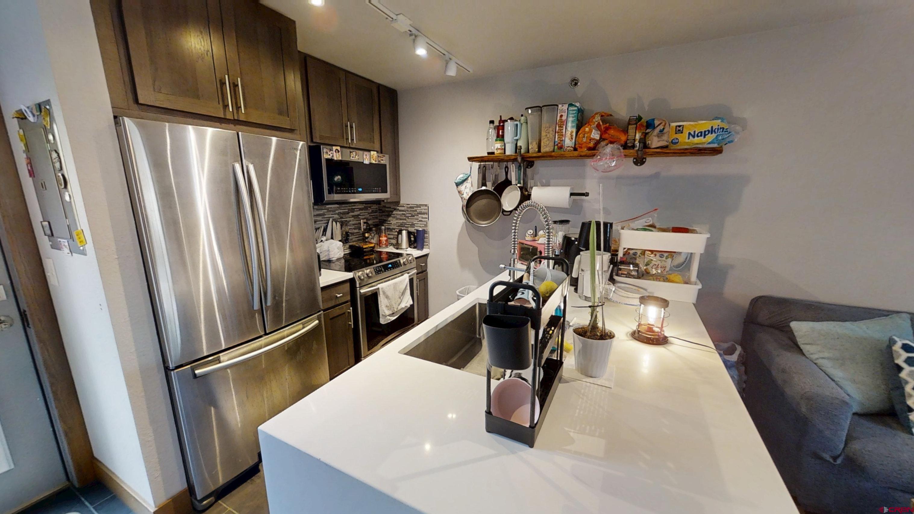 315 East 8th Avenue, Unit 203 Durango, CO 81301 - Photo 8 of 15 a kitchen with stainless steel appliances granite countertop a refrigerator and a sink