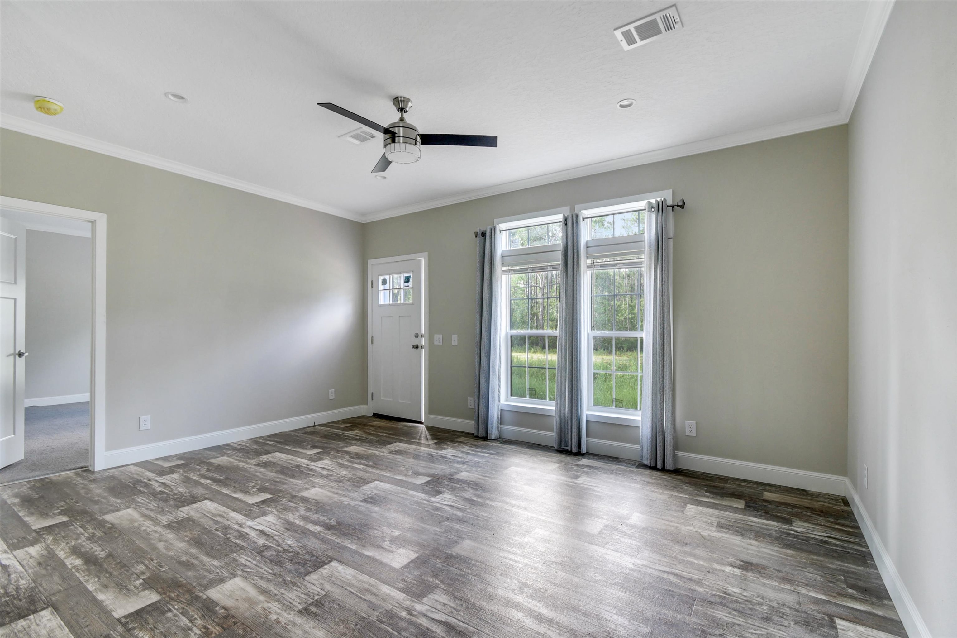 4240 Isaac Street Hastings, FL 32145 - Photo 11 of 19 Spare room with crown molding, a ceiling fan, and wood finished floors