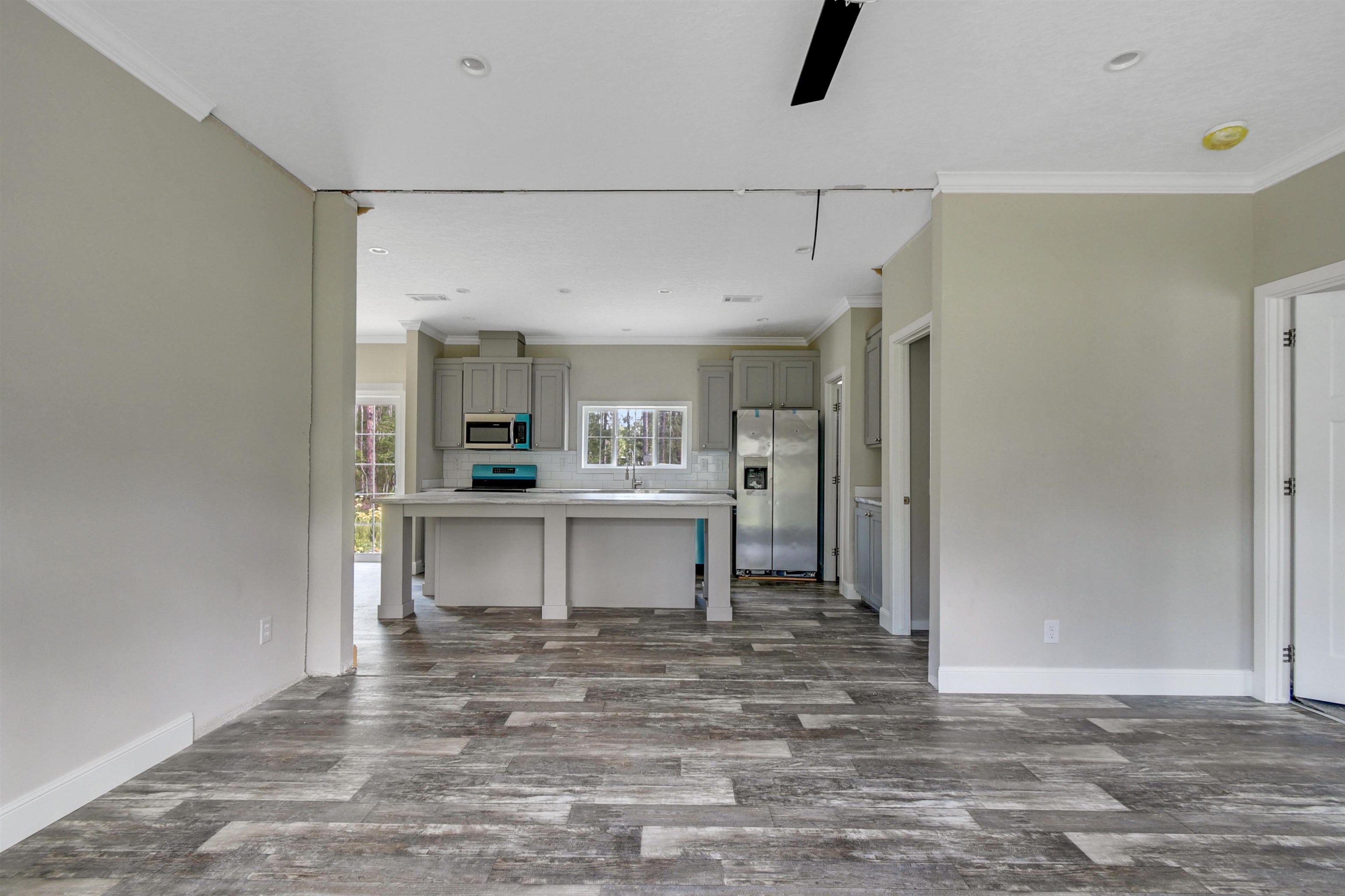 4240 Isaac Street Hastings, FL 32145 - Photo 13 of 19 Unfurnished living room featuring ornamental molding, dark wood finished floors, and recessed lighting