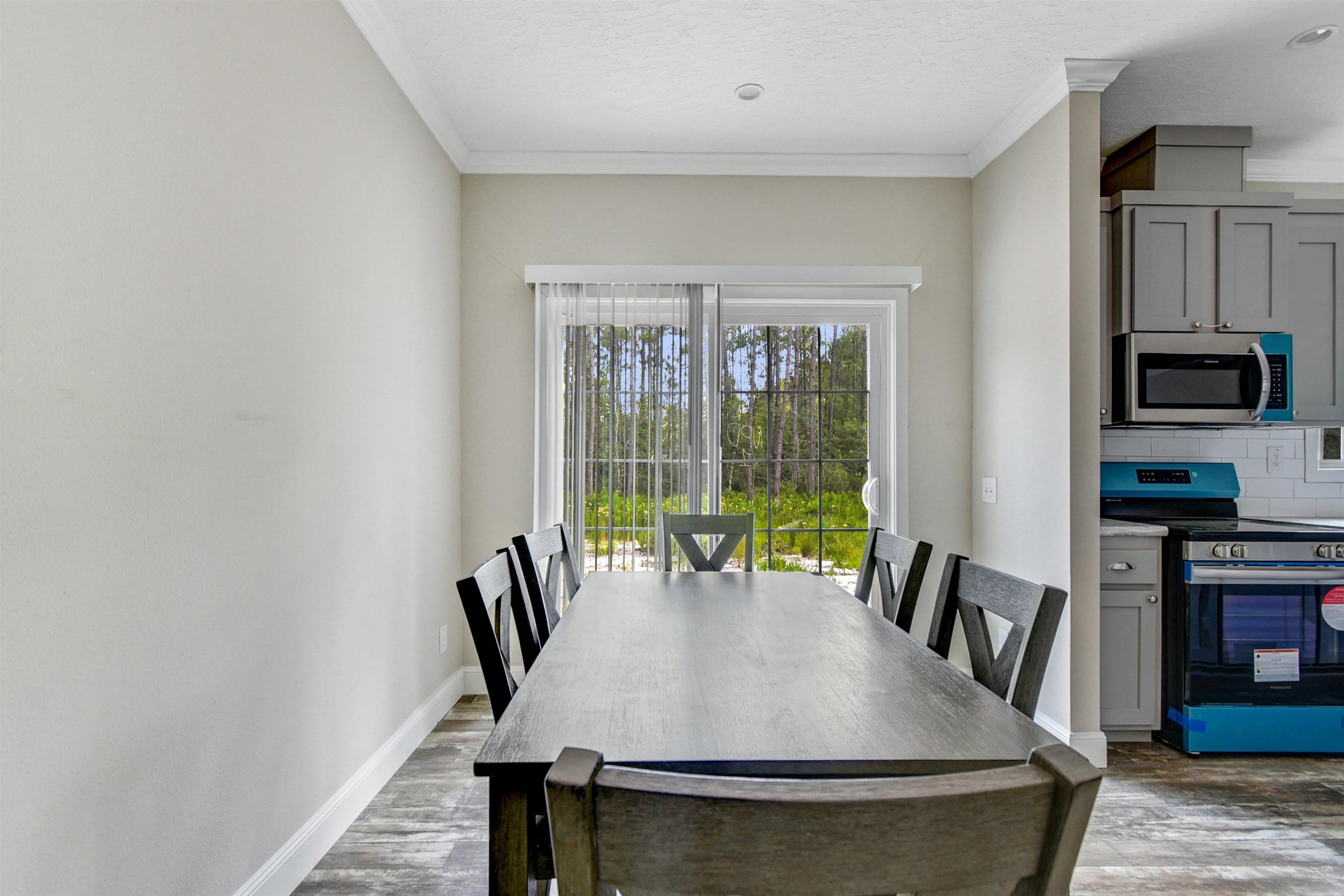 4240 Isaac Street Hastings, FL 32145 - Photo 6 of 19 Dining room featuring ornamental molding, dark wood finished floors, and a textured ceiling