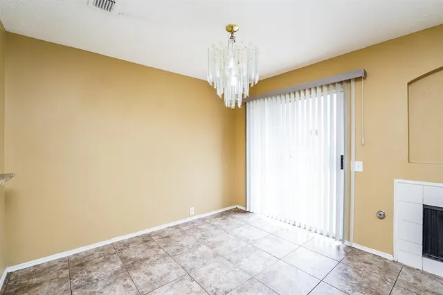 a view of a big room with chandelier fan and windows