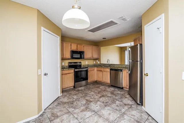 a kitchen with a refrigerator a sink and a stove
