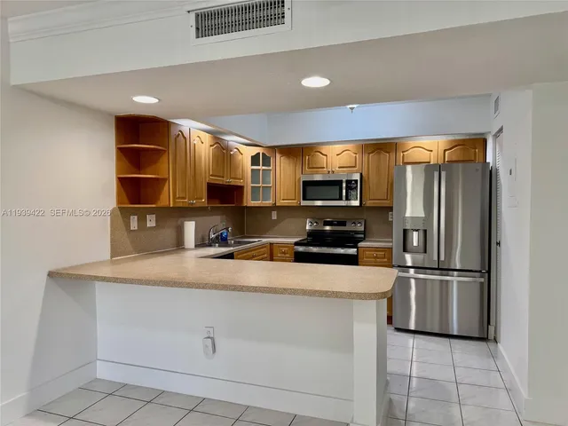 a kitchen with stainless steel appliances a refrigerator sink and microwave