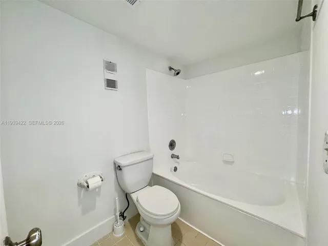a white toilet sitting next to a bath tub shower