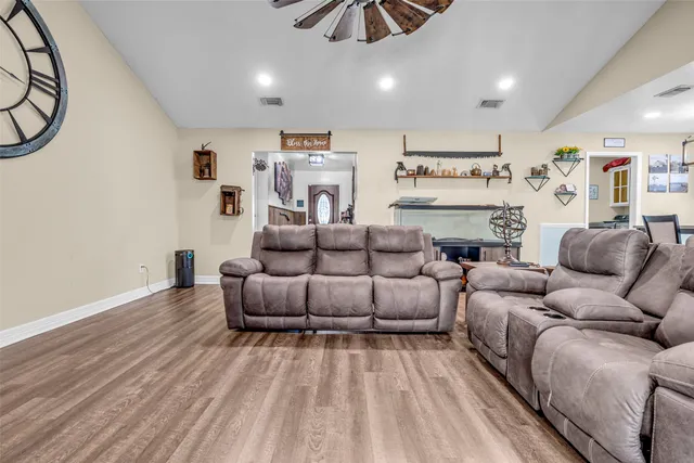 a living room with furniture and a wooden floor