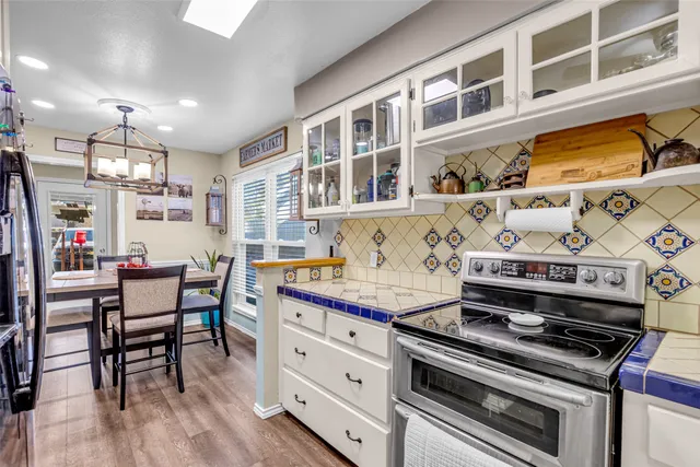a kitchen with a stove and a dining table chair