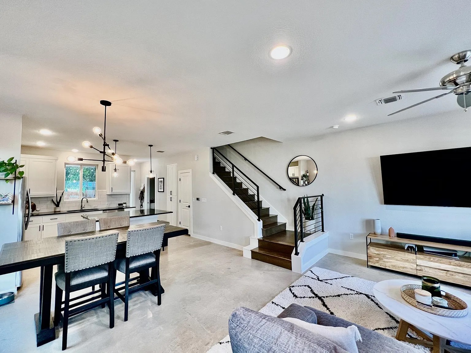 1924 Bunche Road, Unit A Austin, TX 78721 - Photo 3 of 14 Living room with finished concrete floors, hanging lights, and ceiling fan
