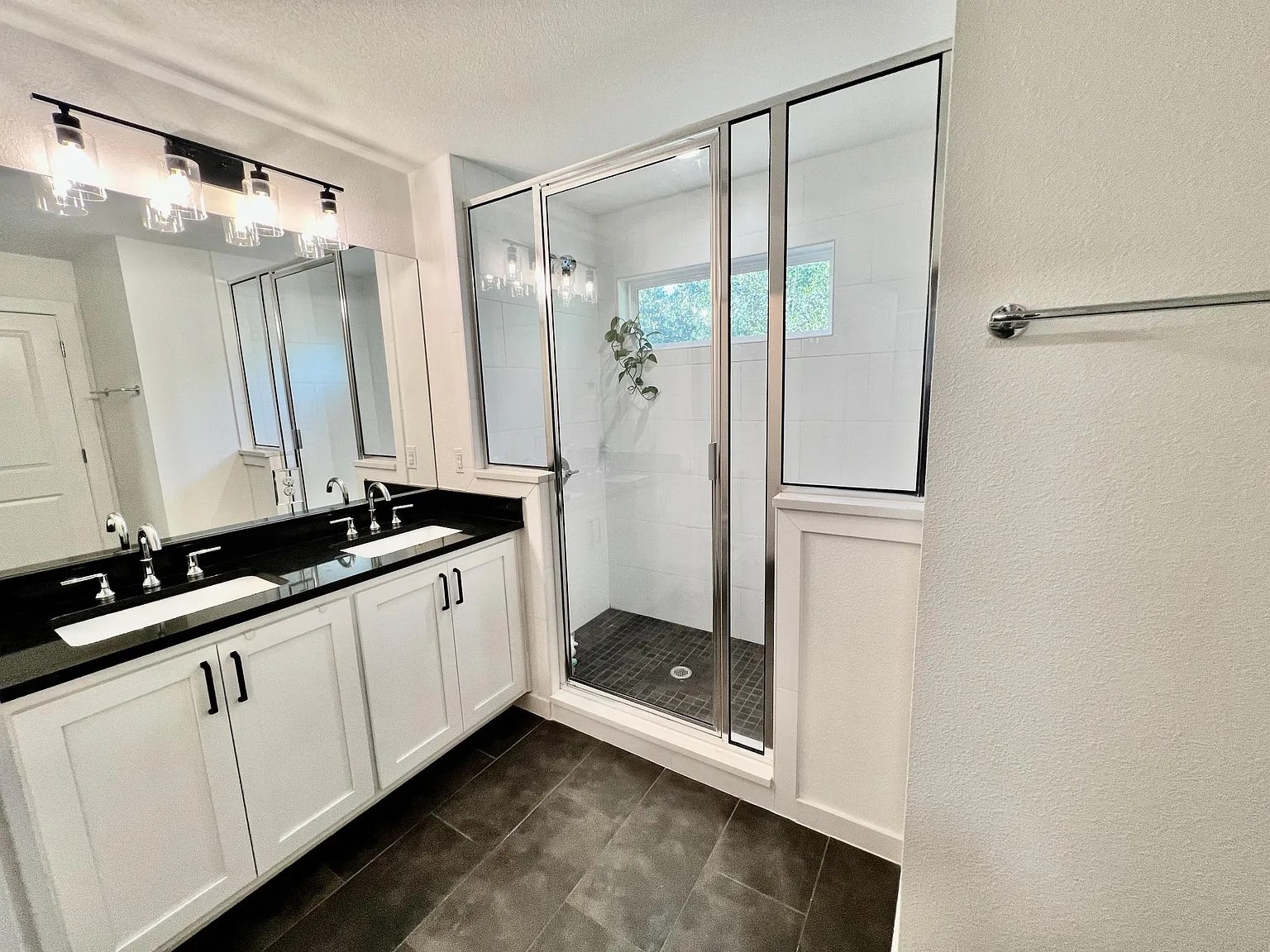 1924 Bunche Road, Unit A Austin, TX 78721 - Photo 8 of 14 Full bath featuring a shower stall, double vanity, a textured wall, and dark tile patterned flooring
