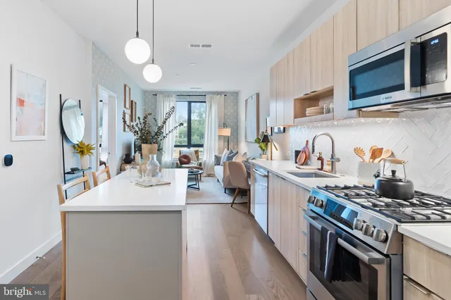 a kitchen with kitchen island granite countertop a sink a stove oven a counter space and cabinets