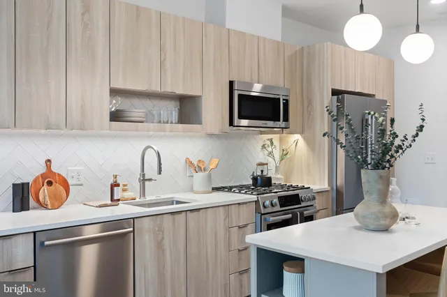 a kitchen with stainless steel appliances a stove a sink a microwave and cabinets