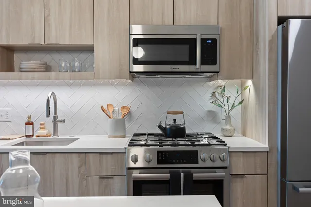 a kitchen with stainless steel appliances a stove and a microwave