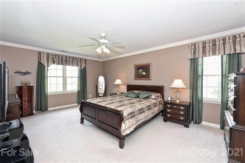 324 Gringley Hill Road Fort Mill, SC 29708 - Photo 18 of 48 a spacious bedroom with a bed and a chandelier